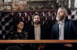 press photo of All the Saints sitting in a booth in a bar.