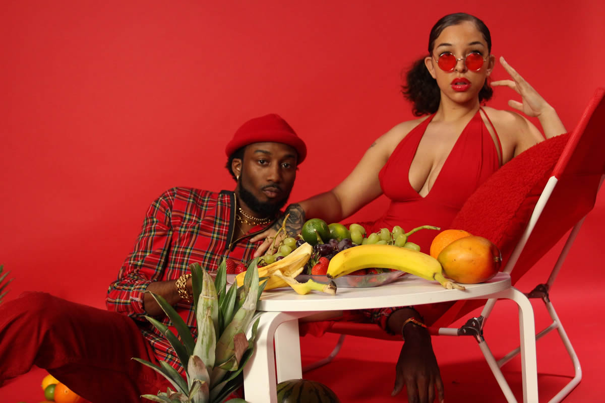 Troop Brand and woman in red lounging with fruit around them.