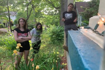 members of SMALL standing in front of a house.