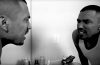 Victor Mariachi looking into a bathroom mirror.