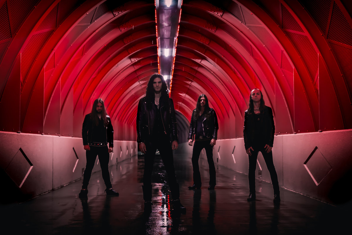 members of Cloak dressed in black and standing in a tunnel.
