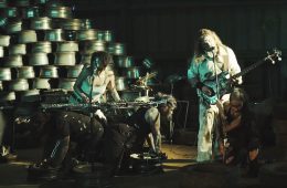 members of Dead Register on a sound stage performing with industrial backdrop.