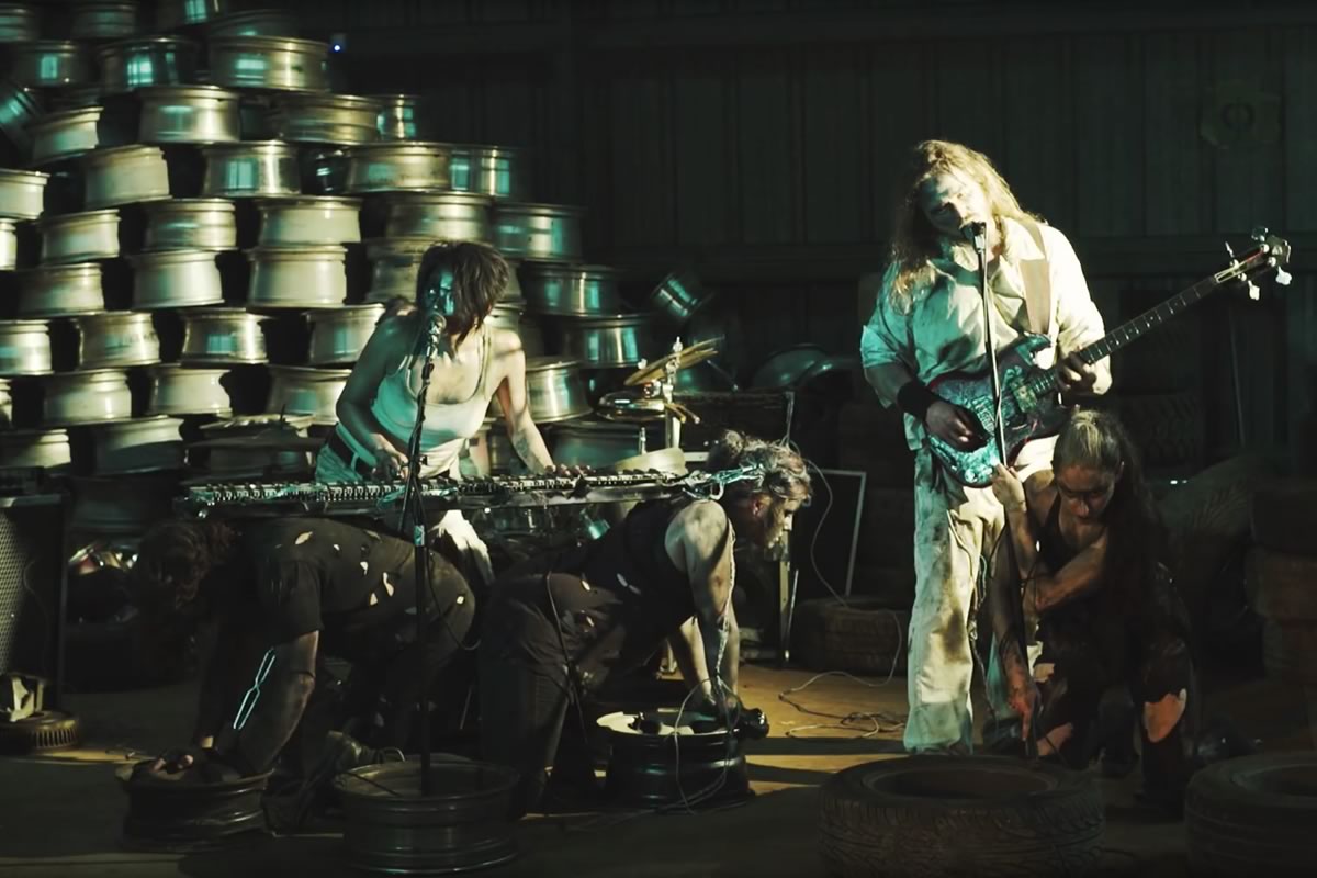members of Dead Register on a sound stage performing with industrial backdrop.