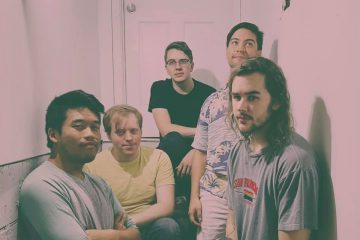 members of Fevergreen sitting and standing in a stairwell.