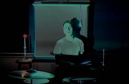 Omni Sincerely Yours video still with drummer in background.