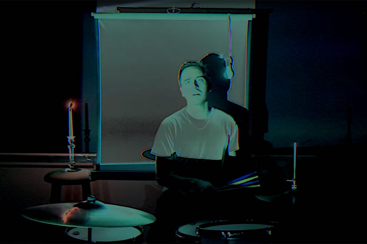 Omni Sincerely Yours video still with drummer in background.