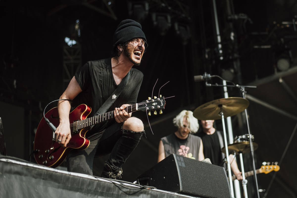 Jordan Cook yelling at crowd while playing guitar