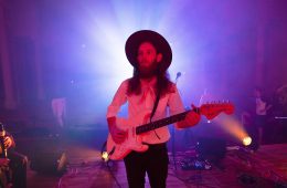 Matthew Pendrick wearing cowboy hat and playing guitar