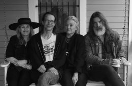 members of Magnapop sitting on a bench