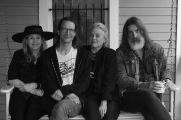 members of Magnapop sitting on a bench