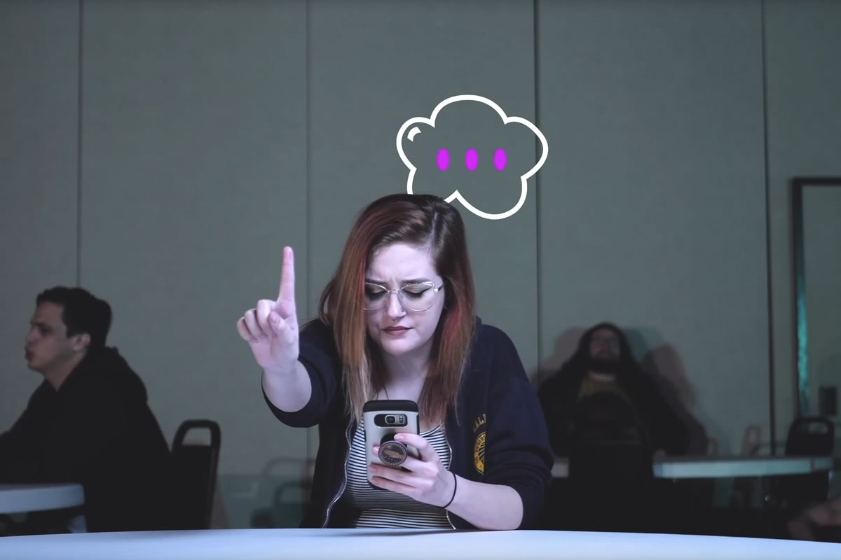 girl on a cell phone holding one finger up