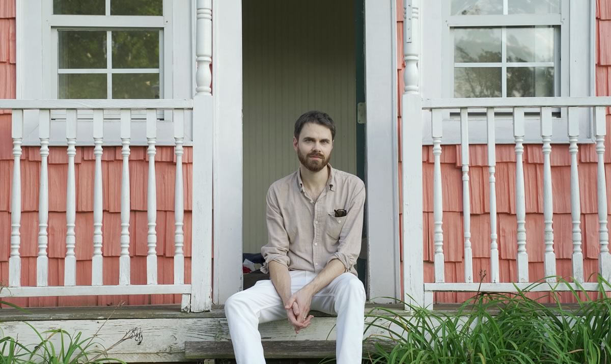 David Norbery sitting on the steps of a porch.