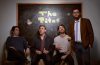 members of The Titos sitting in front of chalkboard