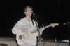 Elijah Johnston playing a guitar onstage.