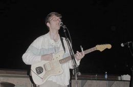 Elijah Johnston playing a guitar onstage.