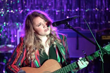 Kristen Englenz playing an acoustic guitar