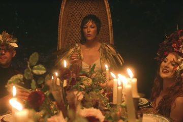 Seersha sitting in a chair at the end of a banquet table.
