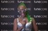 woman with green hair smiling with a microphone in TuneCore booth