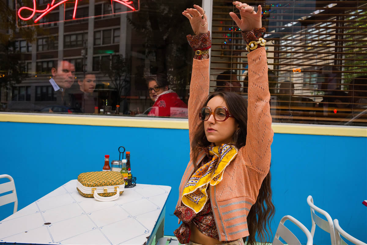 Nadia Marie sitting with arms raised in the air.