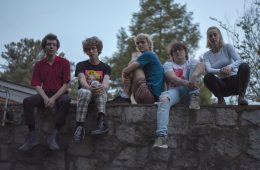 Members of Silver Lake Waves sitting on a wall.