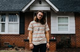 Tommy Trautwien standing in front of a house.
