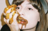 Faye Webster with mouth covered in chocolate gold coins.
