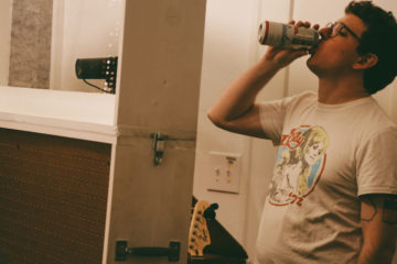 Justin Green of Mountain PArty drinking a Budweiser in the studio.