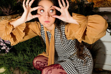 Nadia Marie crouching down and making bug eyes.