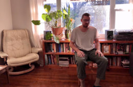 George Huntington sitting in a chair in his living room.