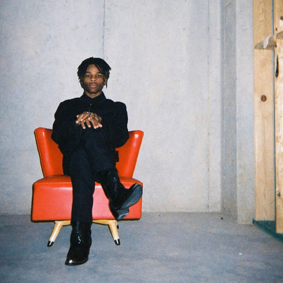 Hollow Sinatra sitting in a red chair.