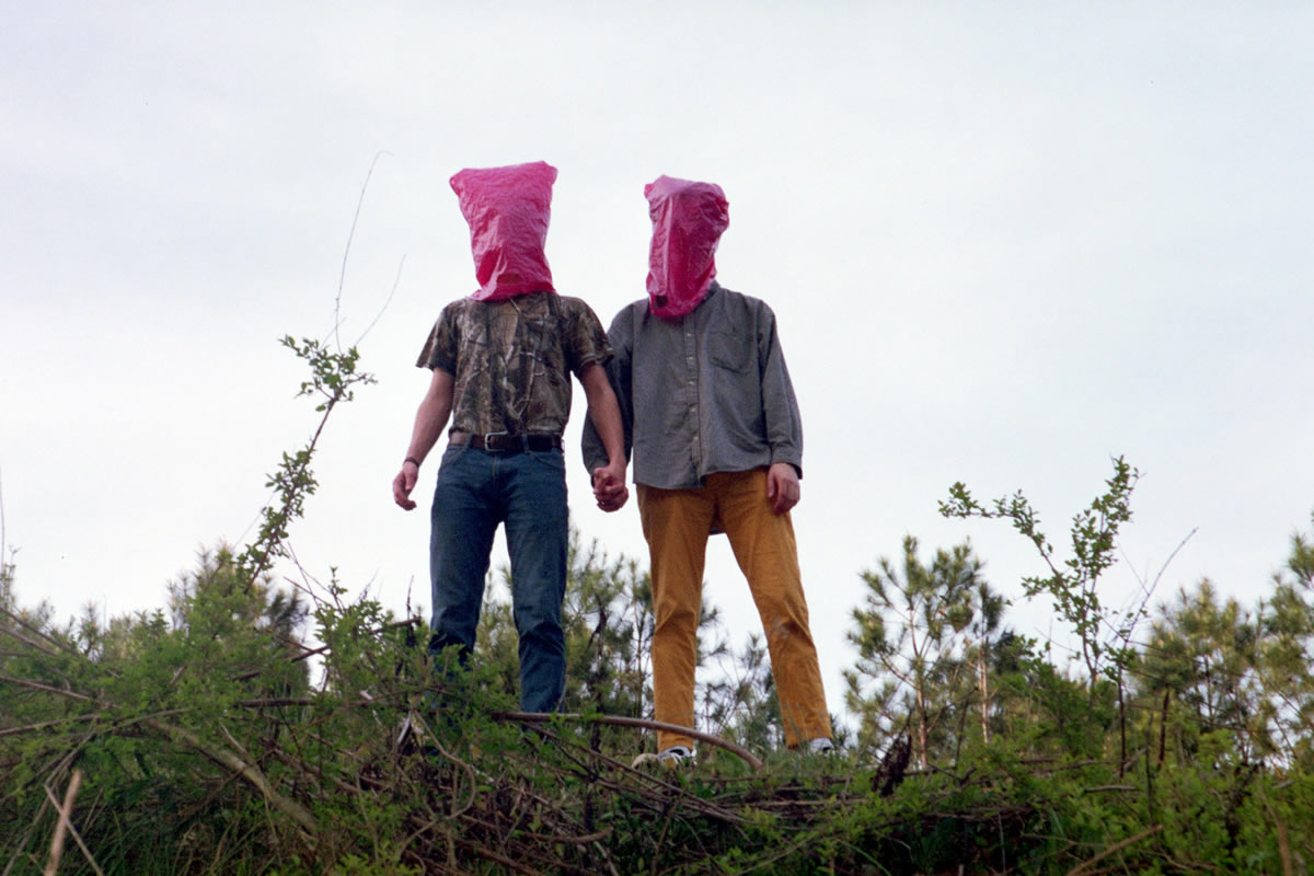 two members of Vangas wearing pink bags over their heads.