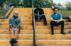 Members of Young Antiques sitting on concrete stairs