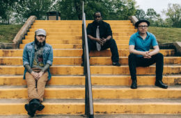 Members of Young Antiques sitting on concrete stairs