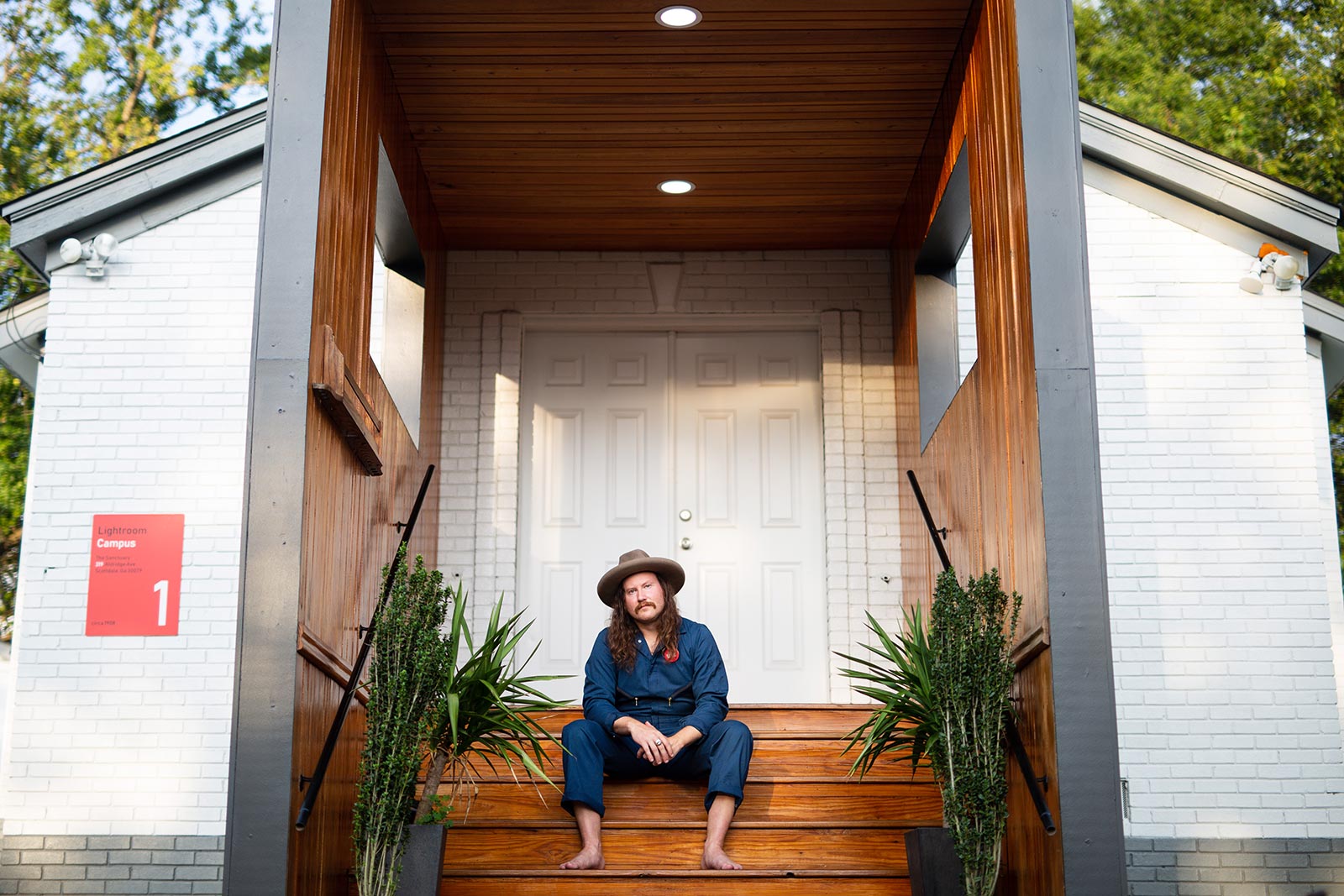 Damon Moon sitting on steps of new entrance to Standard Electric Recorders