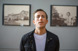 Josh Parsons of Cowboy Curtys standing in front of two photographs