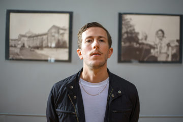 Josh Parsons of Cowboy Curtys standing in front of two photographs