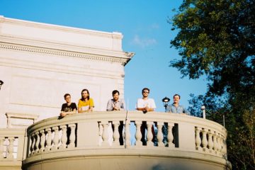 Members of Rujen standing on a balcony.