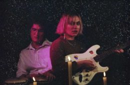 Steph Rinzler and Josh Hughes of Stevie Dinner playing with candles around them
