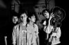 Four members of Deerhunter in Black an white with Bradford Cox holding a guitar over his shoulder