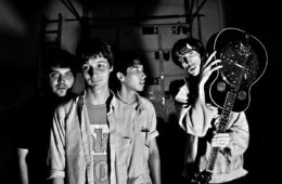 Four members of Deerhunter in Black an white with Bradford Cox holding a guitar over his shoulder