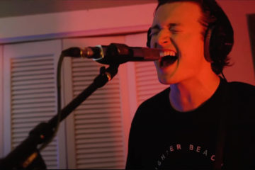 Tommy Trautwein of Well Kept wearing a black shirt and singing into a microphone