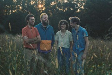 members of bandanna standing in an open field