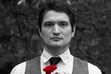 Black and white photo of Sean Bryant of Big Brutus with red rose