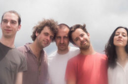members of Karaoke standing against a gray backdrop