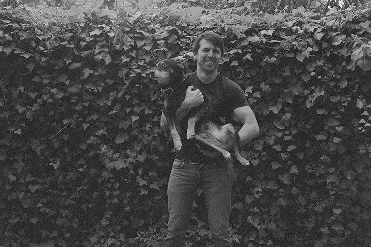 black and white photo of Zachary Batson holding a dog