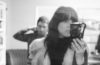 Andrea Rogers of Nights Driving in Small Towns holding a camera with Colby Wright in the background
