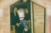 Tommy and Holyn Trautwein sitting in a small room with plain wooden walls