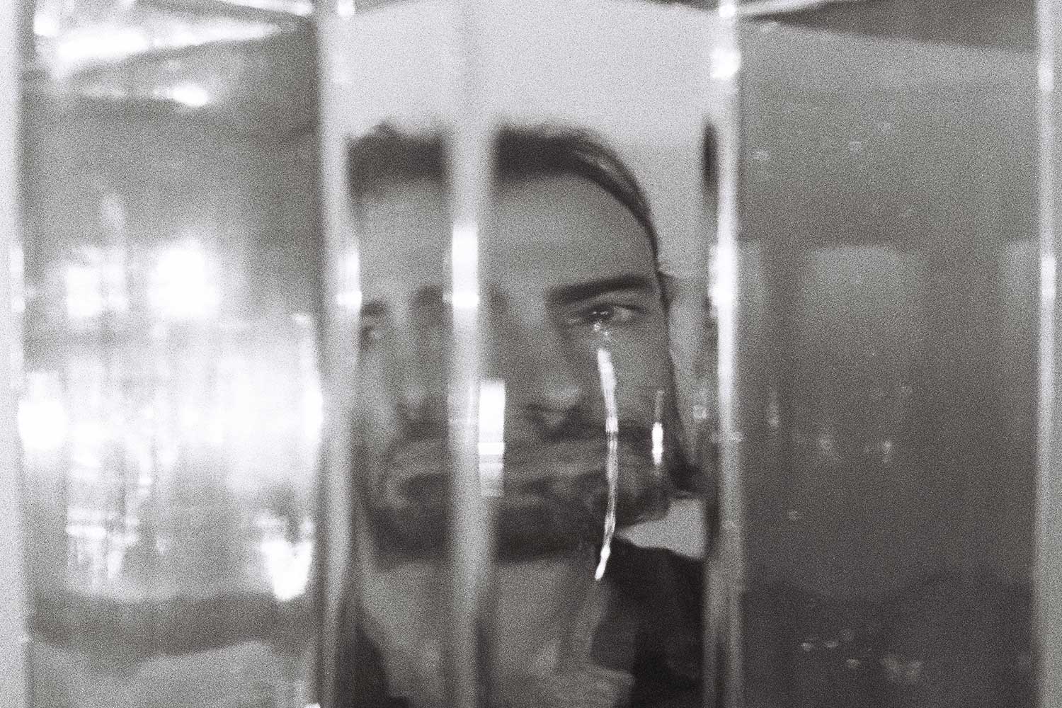 portrait of Chandler Kelley of Canopy Joc distorted through glass vases