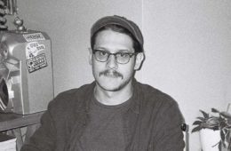 black and white photo of Christian Perez (Hark) sitting in a chair