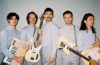 press photo of members of Wanderwild all wearing gray and holding their instruments
